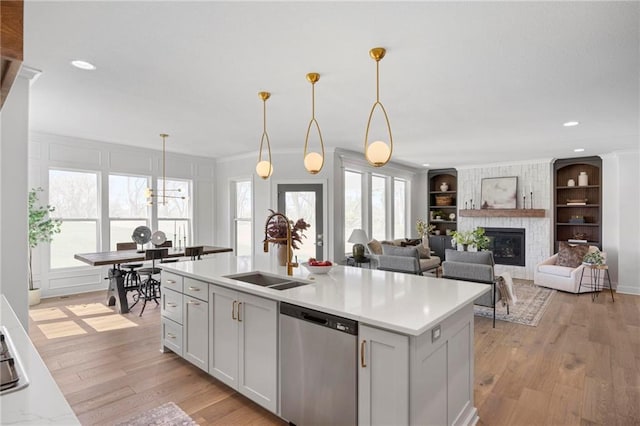 18452 Windsor St, Overland Park, KS 66085 - kitchen with light wood finished floors, light countertops, a sink, built in shelves, and dishwasher