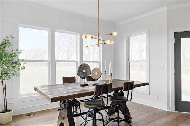 18452 Windsor St, Overland Park, KS 66085 - dining area featuring light wood-style flooring, visible vents, crown molding, and an inviting chandelier