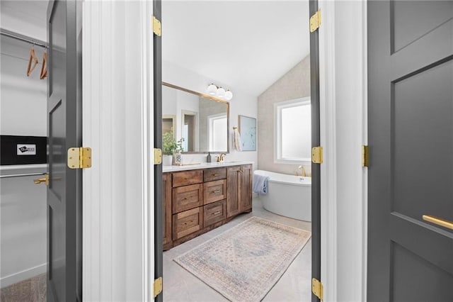 18452 Windsor St, Overland Park, KS 66085 - bathroom with a freestanding bath, double vanity, vaulted ceiling, and a spacious closet