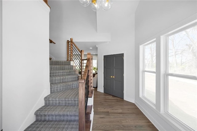 18452 Windsor St, Overland Park, KS 66085 - foyer with baseboards, wood finished floors, a notable chandelier, and stairway