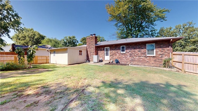 rear view of house with a yard and cooling unit