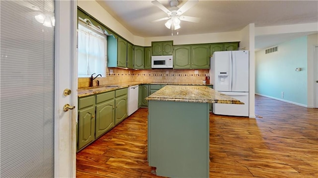 kitchen featuring sink, white appliances, a center island, and decorative backsplash