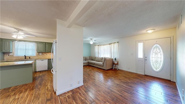 entryway featuring sink, ceiling fan, dark wood-type flooring, and a textured ceiling