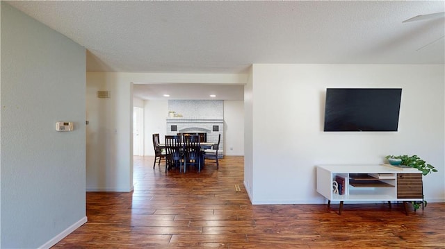 living room with a brick fireplace and dark hardwood / wood-style flooring