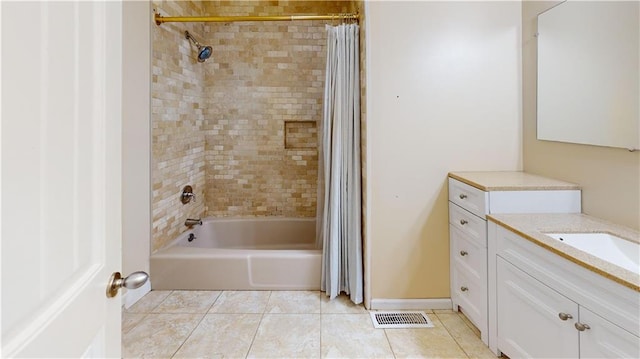 bathroom with tile patterned floors, shower / bath combo with shower curtain, and vanity