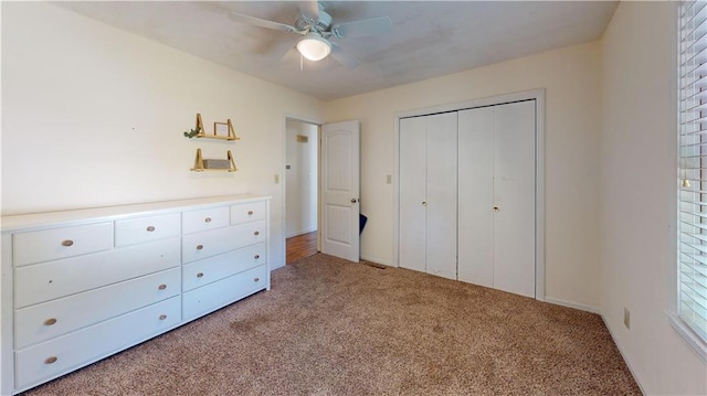 unfurnished bedroom featuring a closet, ceiling fan, and light colored carpet