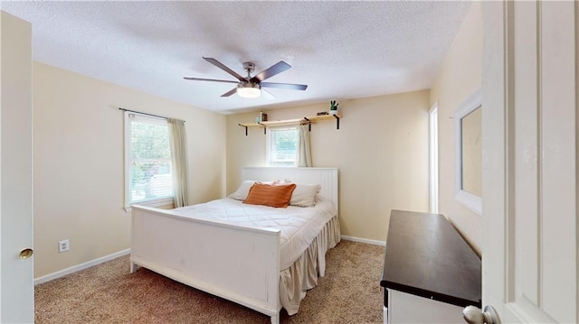 bedroom with a textured ceiling, ceiling fan, and light colored carpet