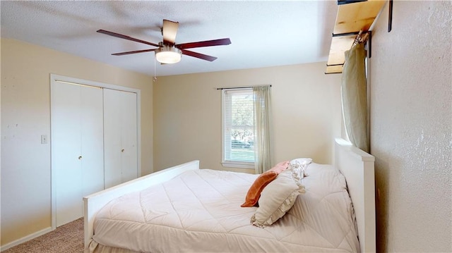 carpeted bedroom with ceiling fan and a closet