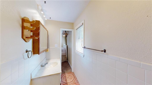 bathroom with tile walls and vanity