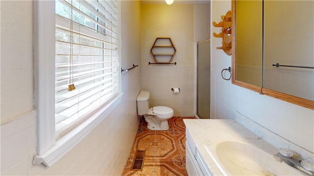 bathroom featuring tile walls, vanity, an enclosed shower, tile patterned flooring, and toilet