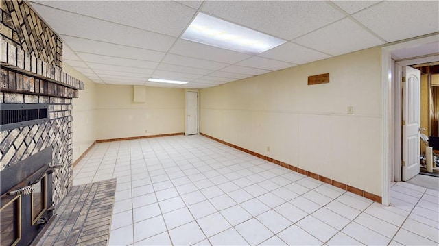 basement with light tile patterned flooring and a drop ceiling