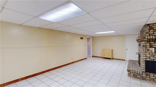 basement featuring a paneled ceiling and a fireplace