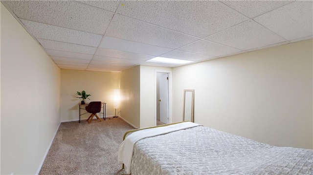 carpeted bedroom featuring a drop ceiling