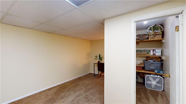 hall featuring a drop ceiling and carpet floors