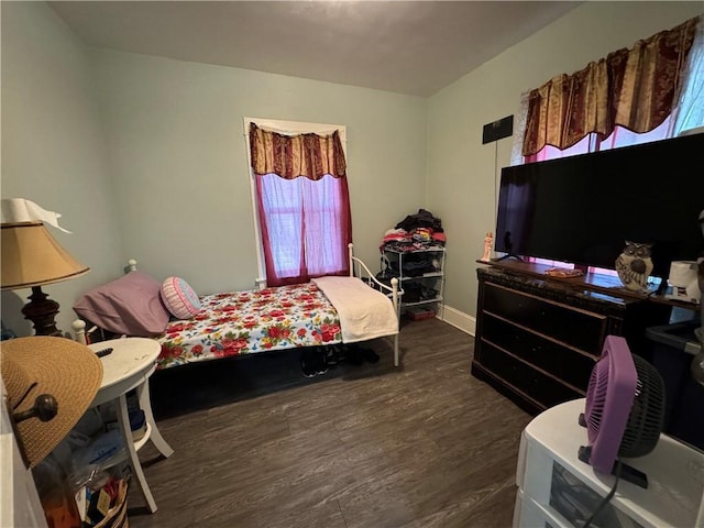 bedroom with dark wood finished floors and baseboards