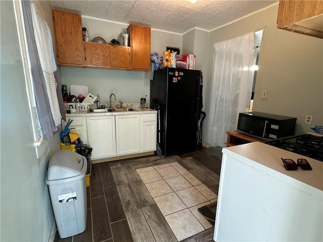 kitchen with light countertops, wood finish floors, black appliances, open shelves, and a sink