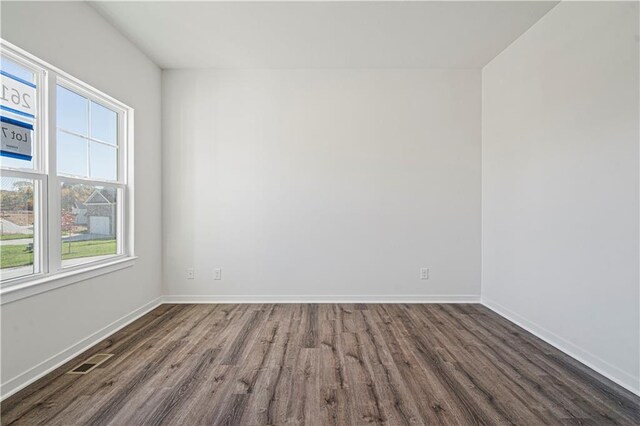 unfurnished room featuring plenty of natural light and dark hardwood / wood-style flooring