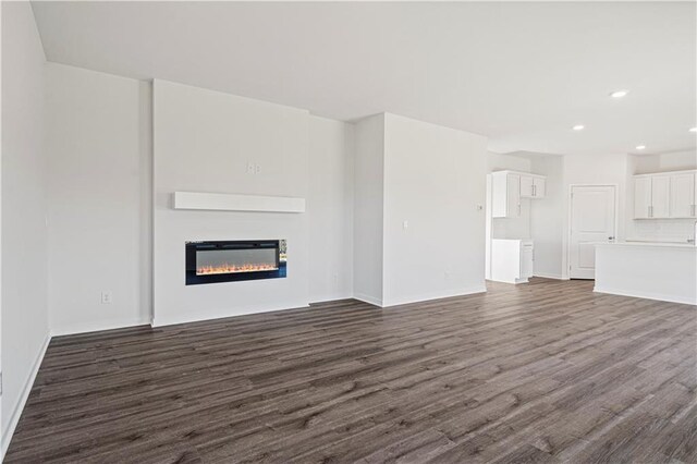 unfurnished living room with dark hardwood / wood-style flooring