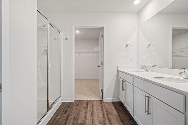 bathroom with vanity, hardwood / wood-style flooring, and a shower with shower door