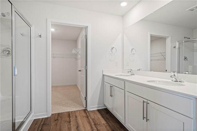 bathroom with vanity, a shower with shower door, and hardwood / wood-style flooring