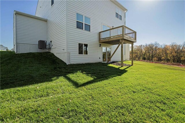 rear view of property featuring a yard, central air condition unit, and a deck