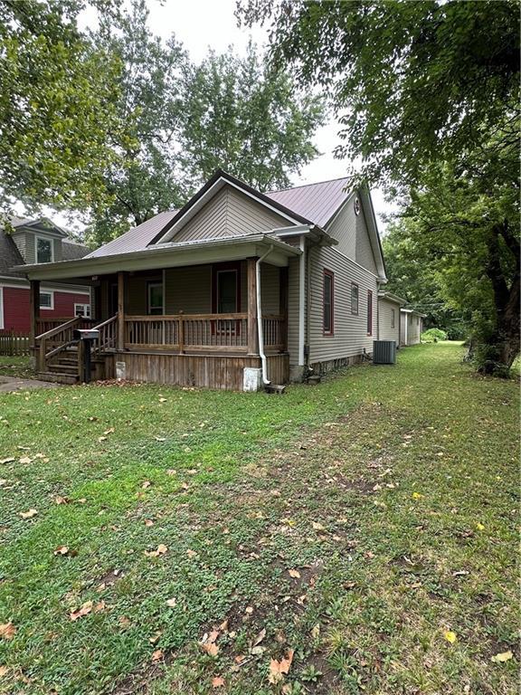 view of front of home with covered porch and a front lawn