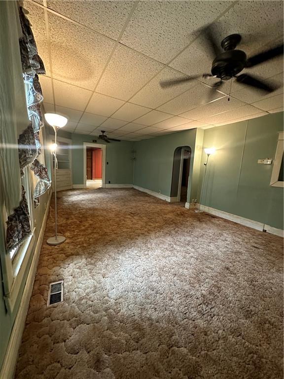 spare room featuring ceiling fan, carpet flooring, and a paneled ceiling