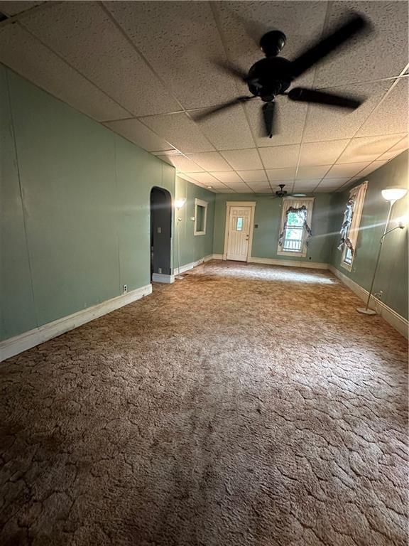 spare room with carpet, ceiling fan, and a drop ceiling