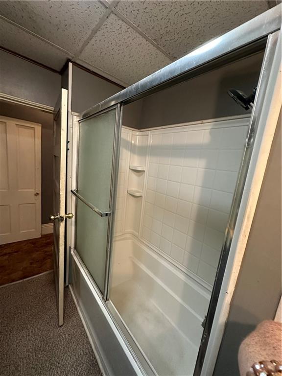 bathroom with bath / shower combo with glass door and a paneled ceiling