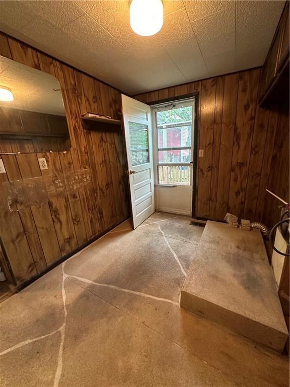 interior space featuring a textured ceiling and wooden walls