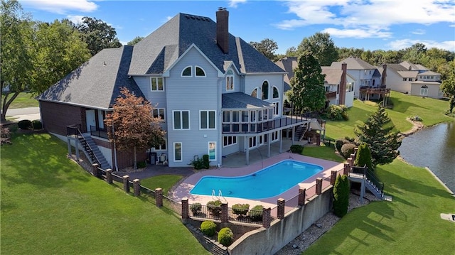 rear view of property featuring a chimney, a lawn, stairway, a patio area, and a fenced backyard