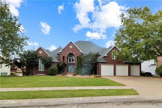 view of front of property with a garage, a front yard, brick siding, and driveway