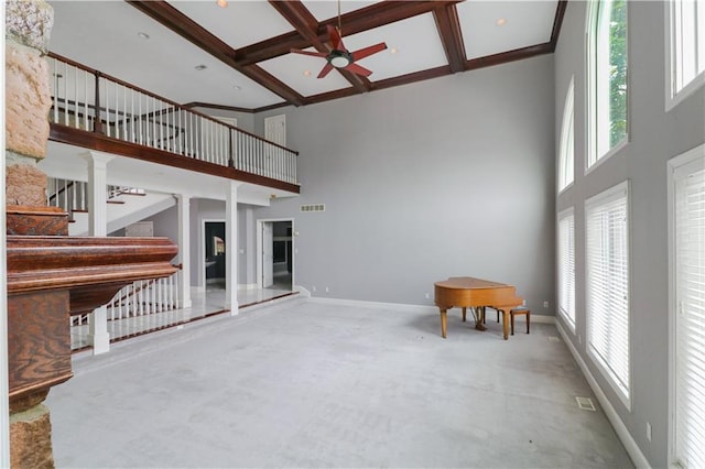 unfurnished living room with coffered ceiling, beam ceiling, and a high ceiling