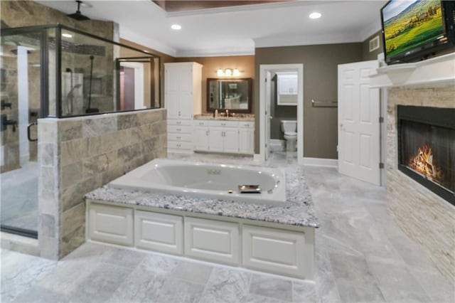 full bath featuring a garden tub, crown molding, toilet, a glass covered fireplace, and a shower stall