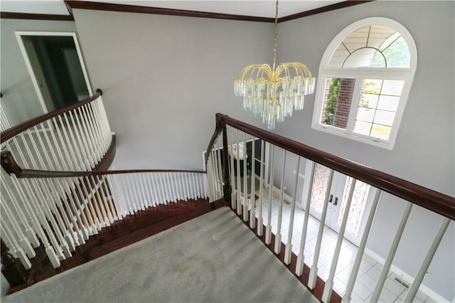 stairway with an inviting chandelier, carpet, and ornamental molding