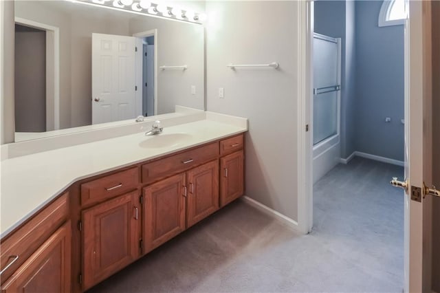 full bathroom featuring baseboards, bath / shower combo with glass door, and vanity