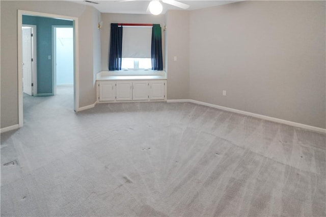 spare room featuring light carpet and ceiling fan