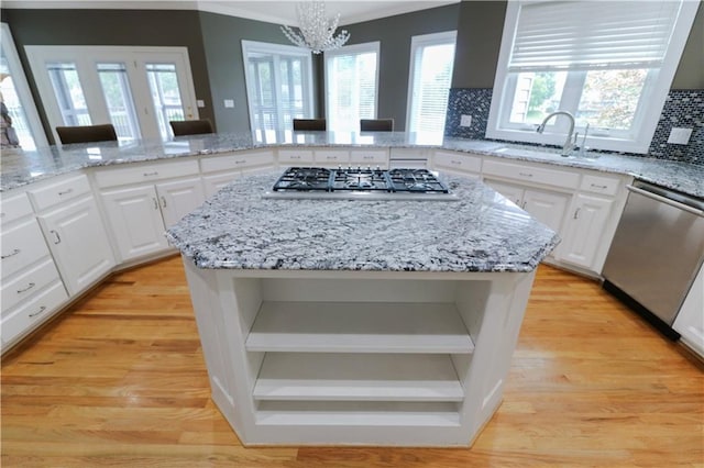 kitchen featuring light hardwood / wood-style flooring, a center island, stainless steel appliances, sink, and white cabinetry