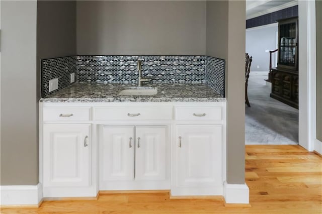 bathroom with a sink, decorative backsplash, and wood finished floors