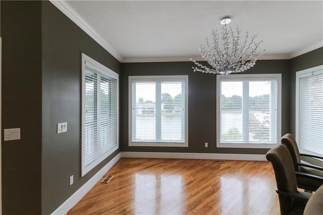 dining room with crown molding, light wood-type flooring, and a chandelier