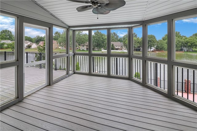 unfurnished sunroom featuring ceiling fan and a water view