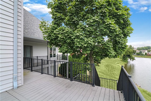 wooden deck featuring a water view and a yard