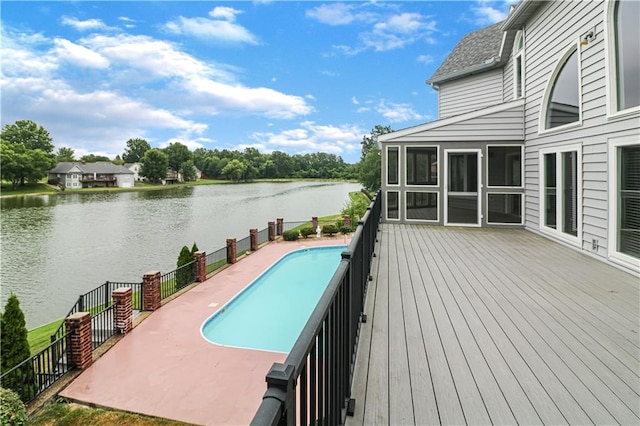 view of swimming pool featuring a water view, a sunroom, and a fenced in pool