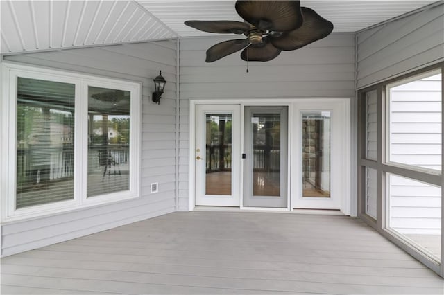 unfurnished sunroom with ceiling fan