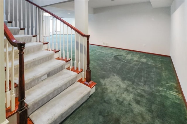 stairs with carpet, visible vents, and baseboards