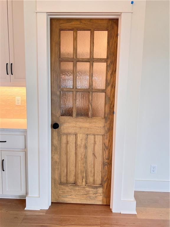 interior details with hardwood / wood-style flooring and tasteful backsplash