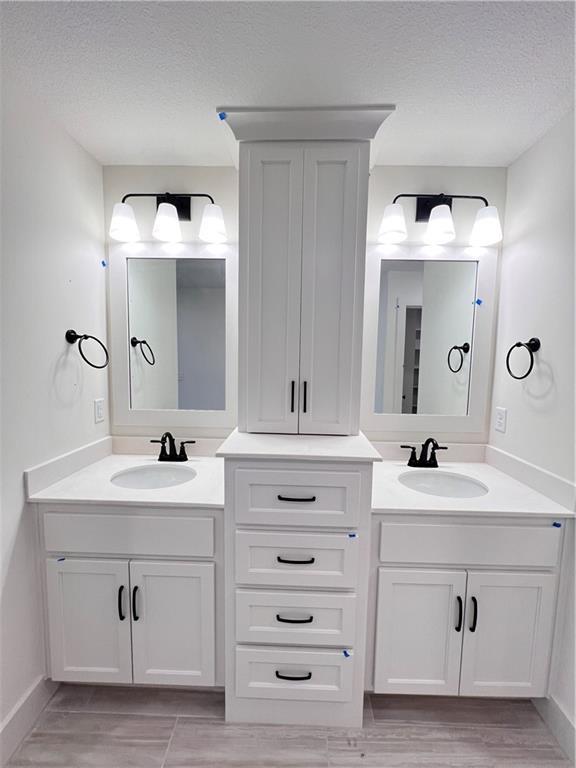 bathroom with hardwood / wood-style flooring, vanity, and a textured ceiling