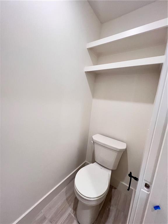 bathroom with toilet and hardwood / wood-style floors