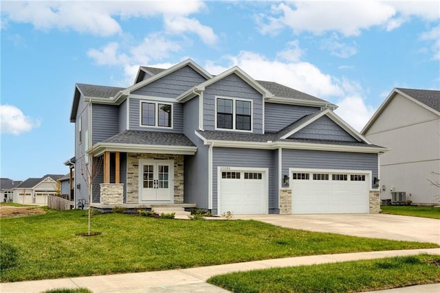 craftsman-style home featuring a garage, central AC unit, covered porch, and a front lawn