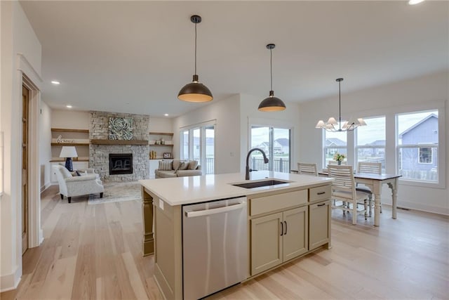 kitchen with sink, stainless steel dishwasher, plenty of natural light, a center island with sink, and light wood-type flooring